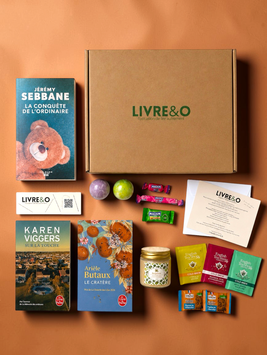 Box Sélection Contemporain LIVRE&O contenant trois romans, des sachets de thé, des gourmandises et des surprises.