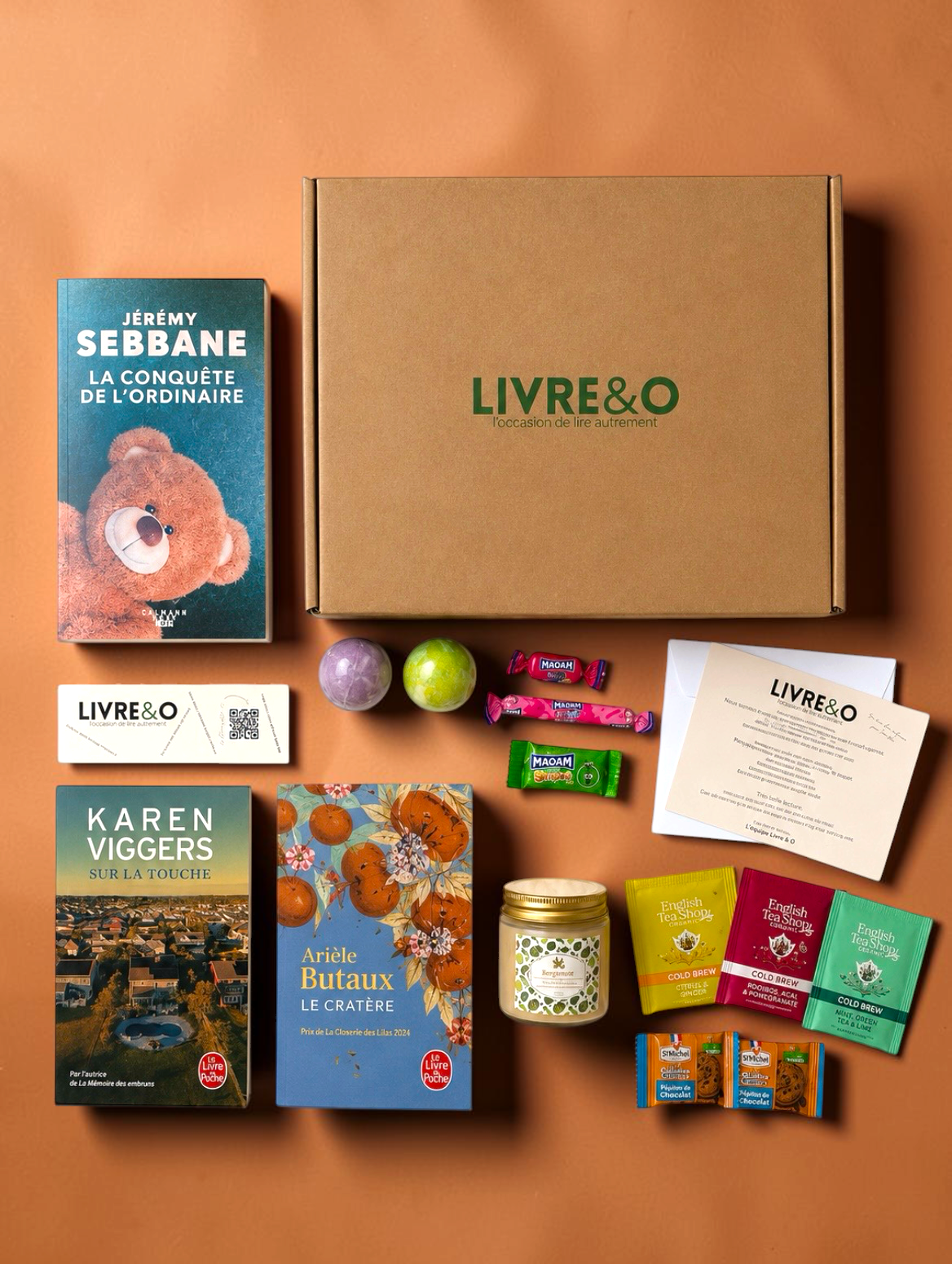 Box Sélection Contemporain LIVRE&O contenant trois romans, des sachets de thé, des gourmandises et des surprises.