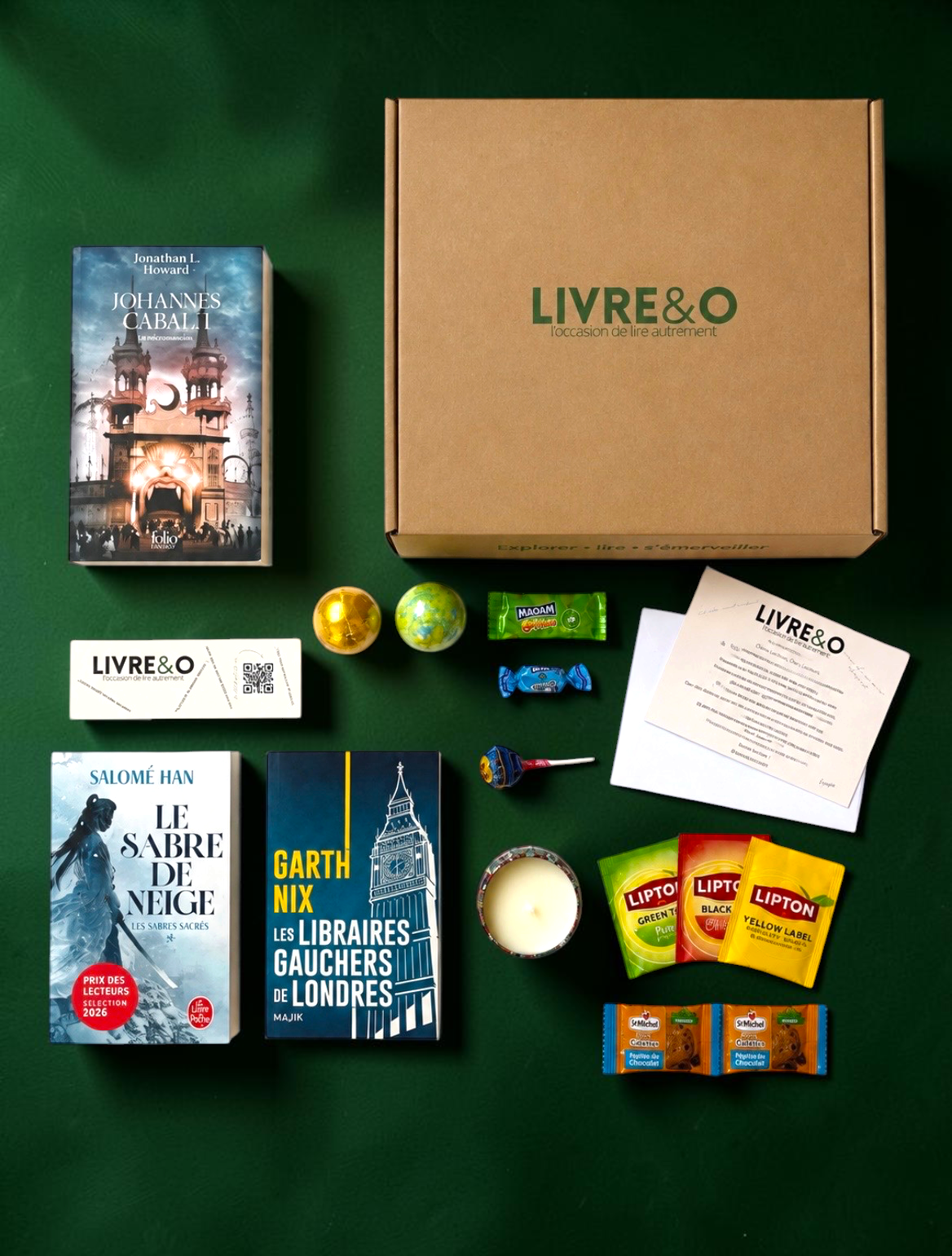 Box Sélection Fantasy LIVRE&O contenant trois romans, une bougie, des sachets de thé et des gourmandises sur fond vert