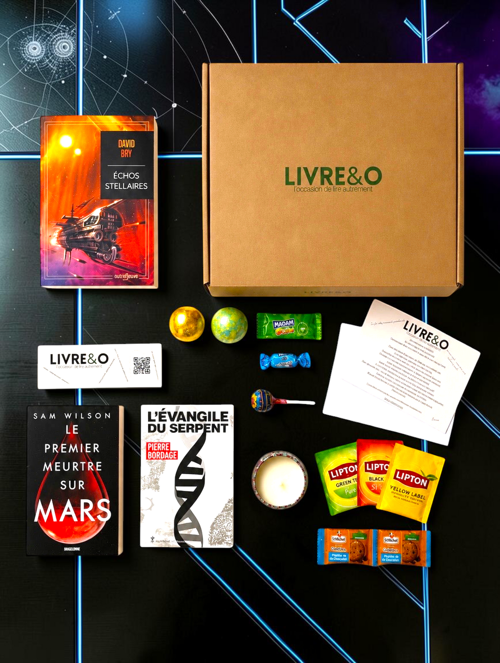 Box sélection science-fiction LIVRE&O contenant trois romans, des gourmandises, du thé et une bougie sur fond spatial