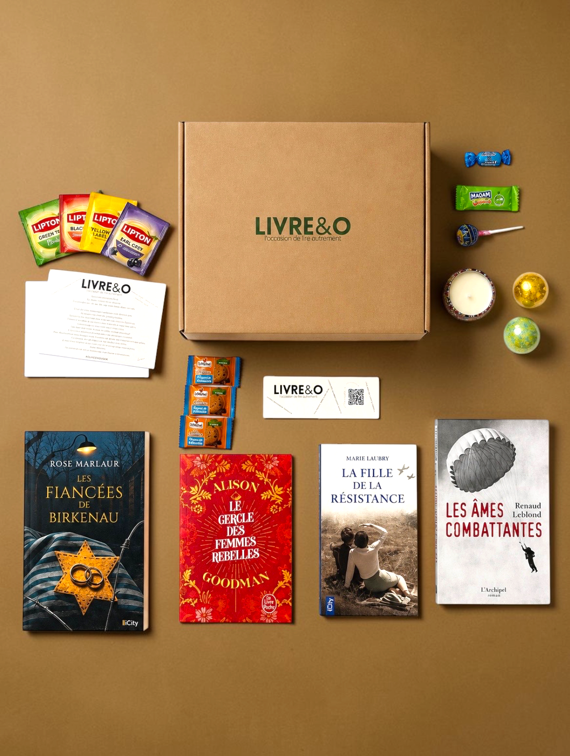 Box Signature Romans Historiques LIVRE&O contenant quatre livres, des sachets de thé, des friandises et une bougie.