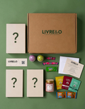 Box surprise LIVRE&O contenant trois livres mystères, des sachets de thé, des gourmandises et une bougie parfumée.