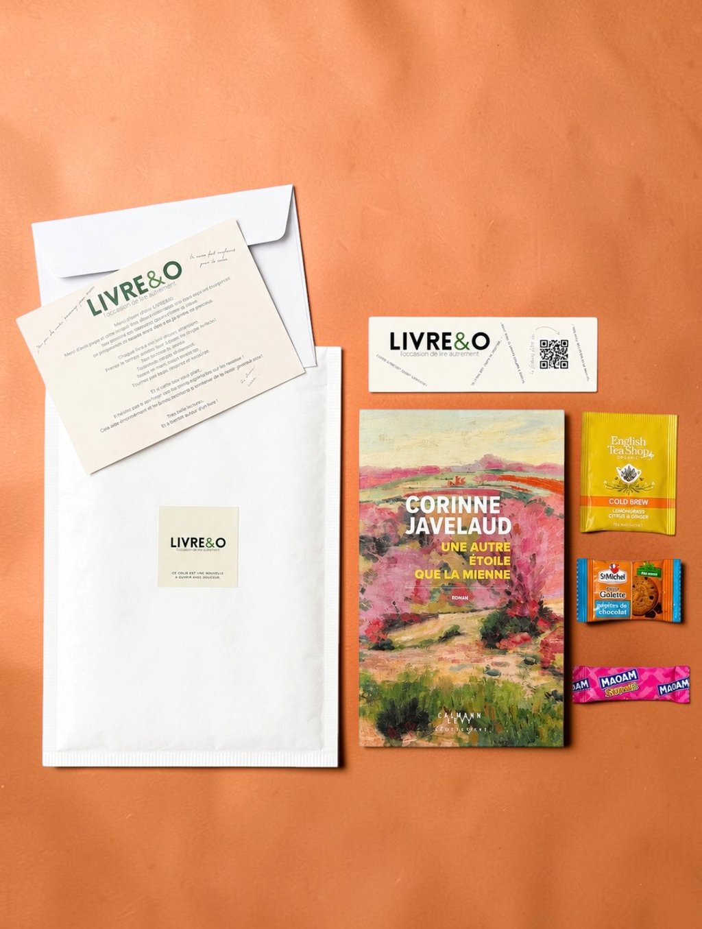 Enveloppe LIVRE&O contenant un roman contemporain, un marque-page, du thé et des gourmandises sur fond orange
