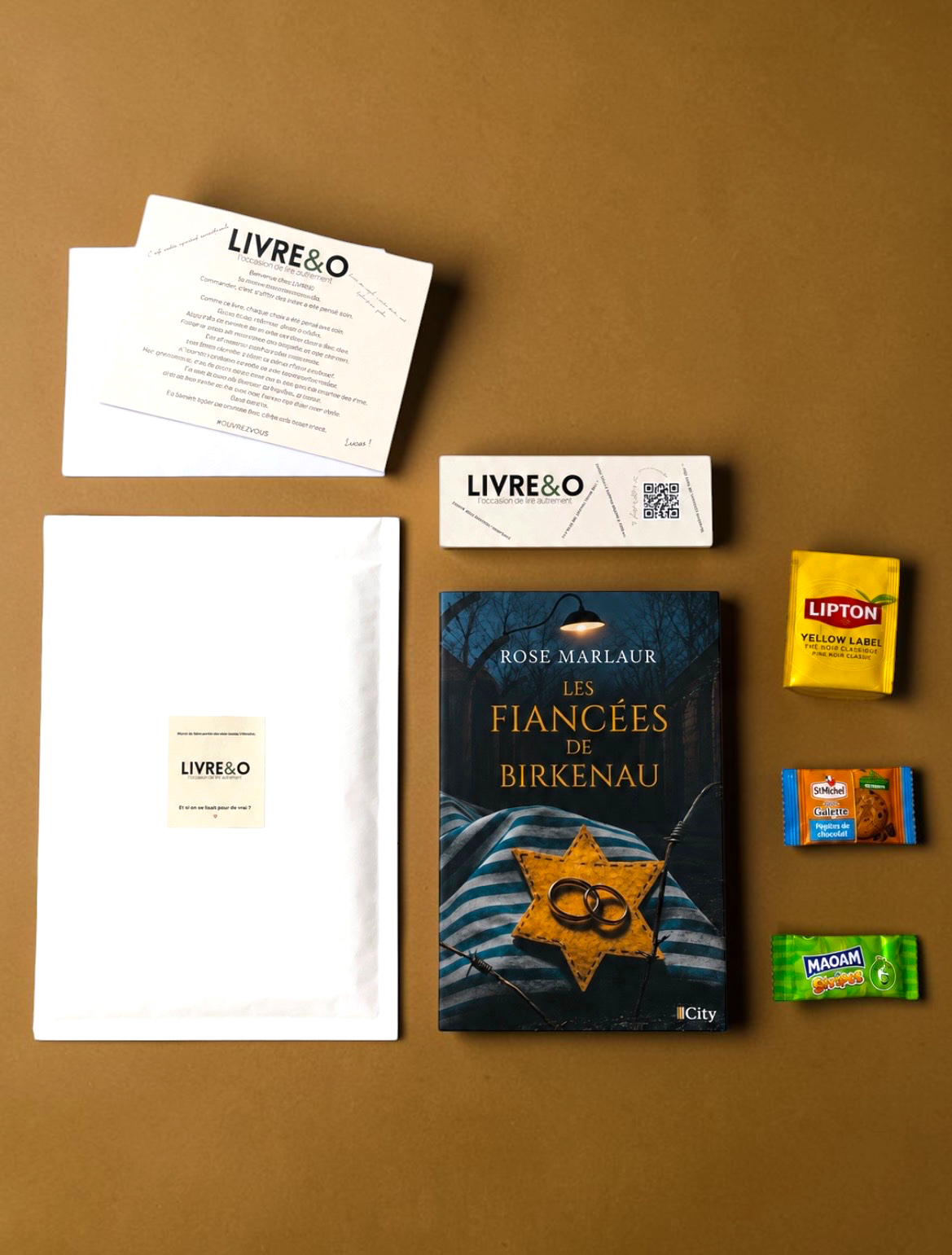 Enveloppe LIVRE&O contenant un roman historique Les Fiancées de Birkenau, des gourmandises et un marque-page